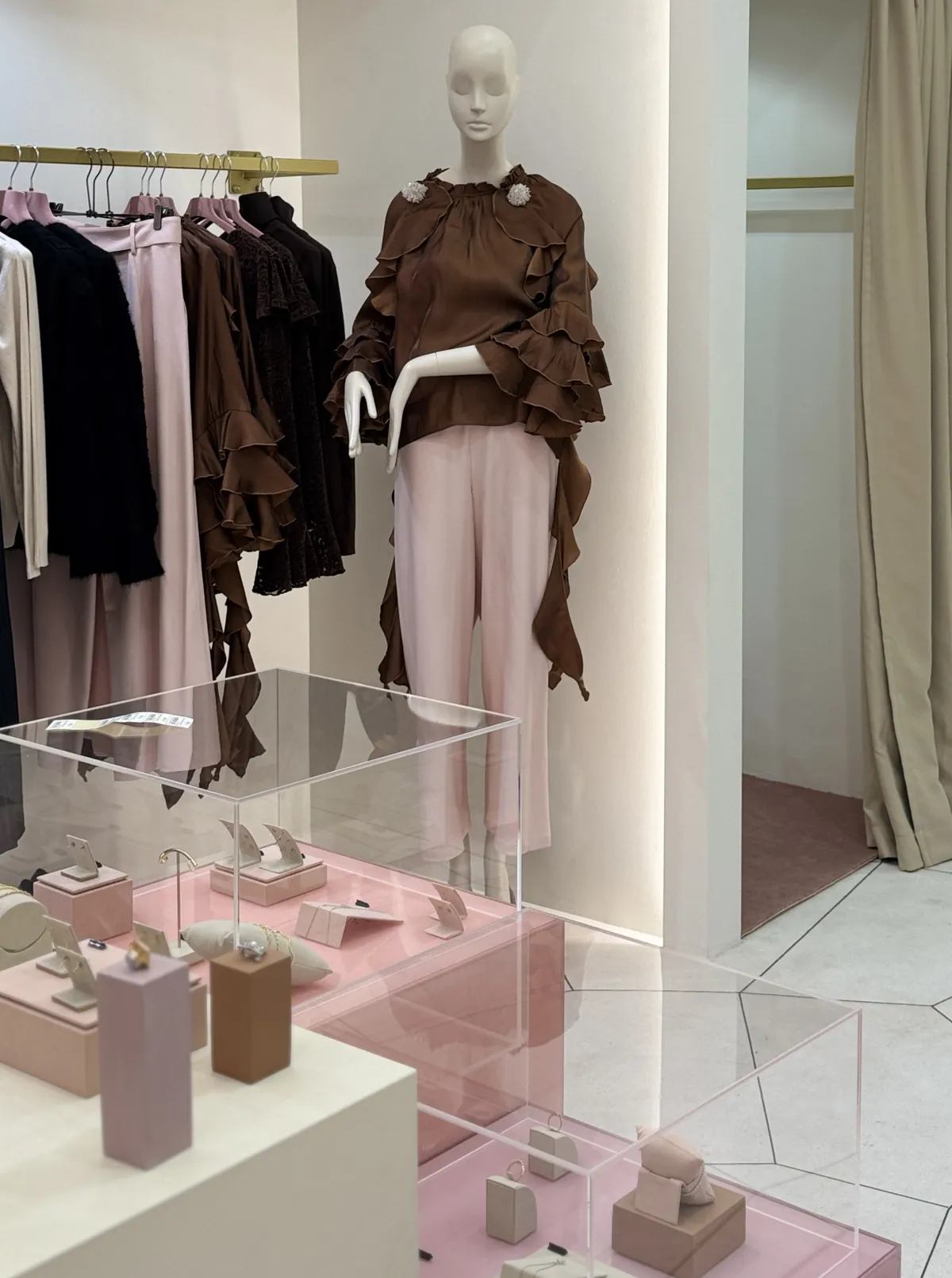 Mannequin in a brown ruffle blouse and pink trousers inside the Firenze boutique