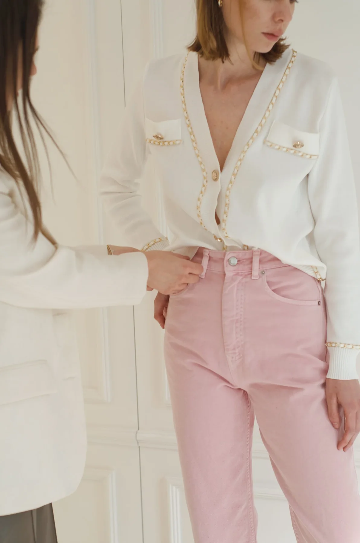 Ivory blouse with delicate trim and soft pink trousers
